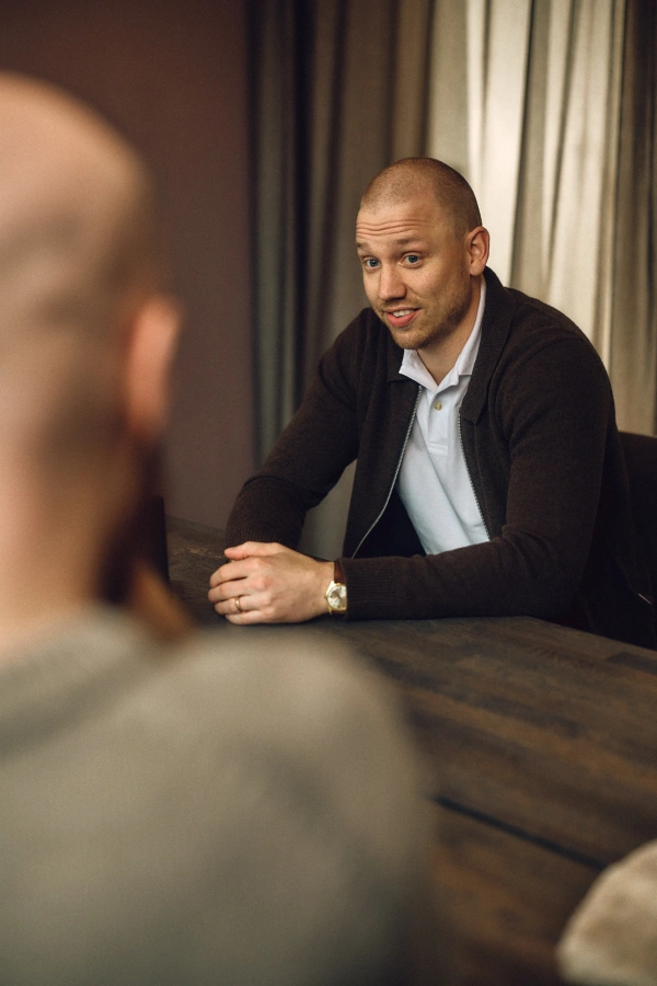 Erik Hallenstål sitter vid ett bord och har ett samtal med kollega.